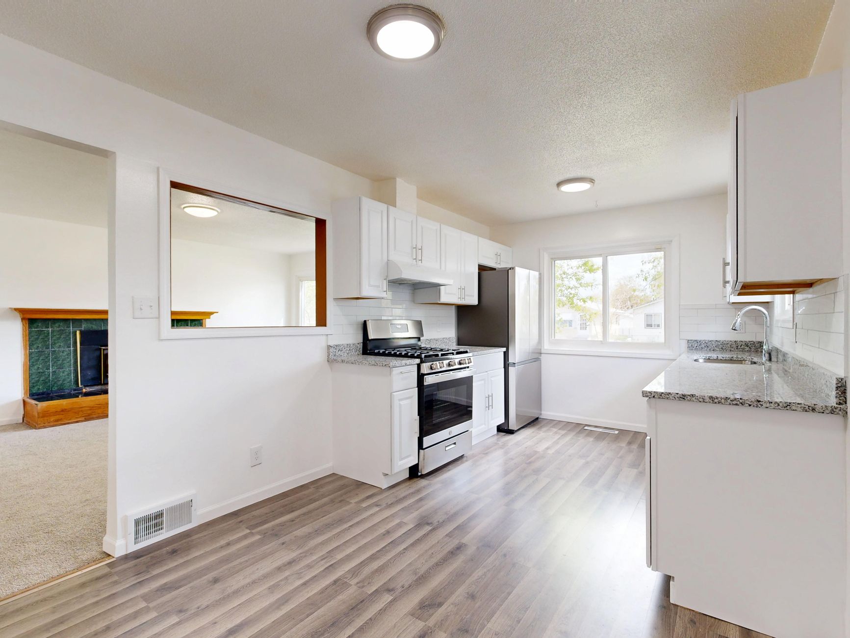 Bright, newly renovated kitchen featuring white cabinets, hardwood floors in Bellevue, WA